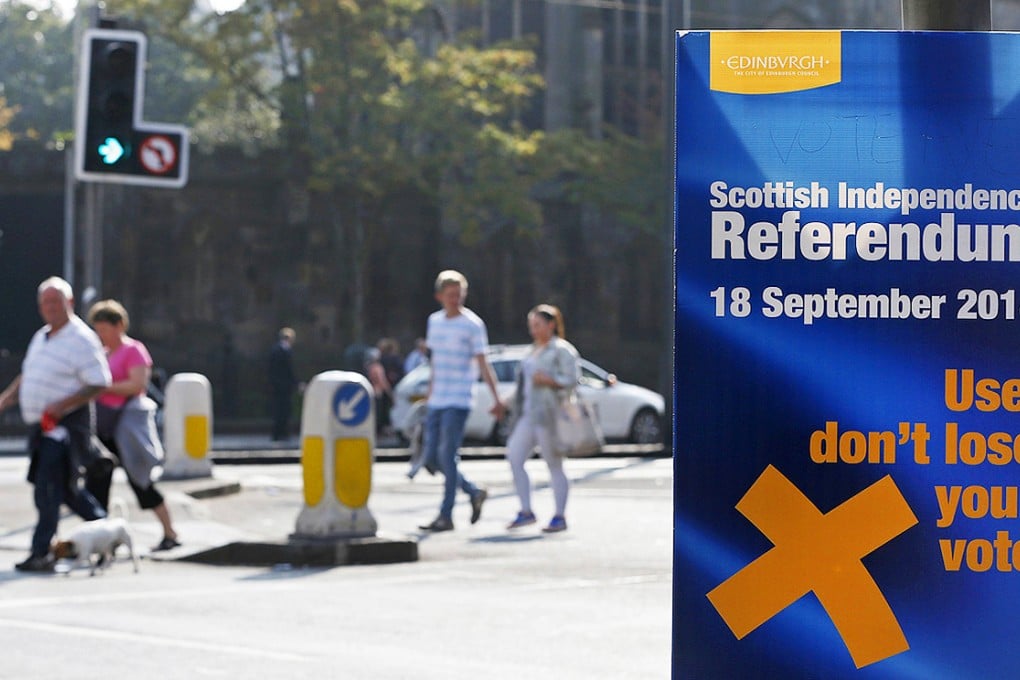 Pedestrians pass a banner urging them to vote in the independence referendum on Princess Street in Edinburgh, Scotland on Thursday. Photo: Reuters