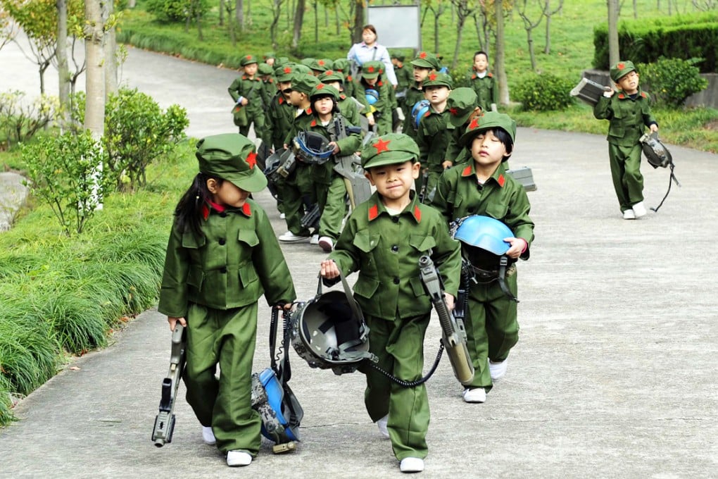 Kindergarten children dressed in military uniforms carry toy guns at a park in Dongyang, Zhejiang province as part of patriotic education lessons. Photo: Reuters