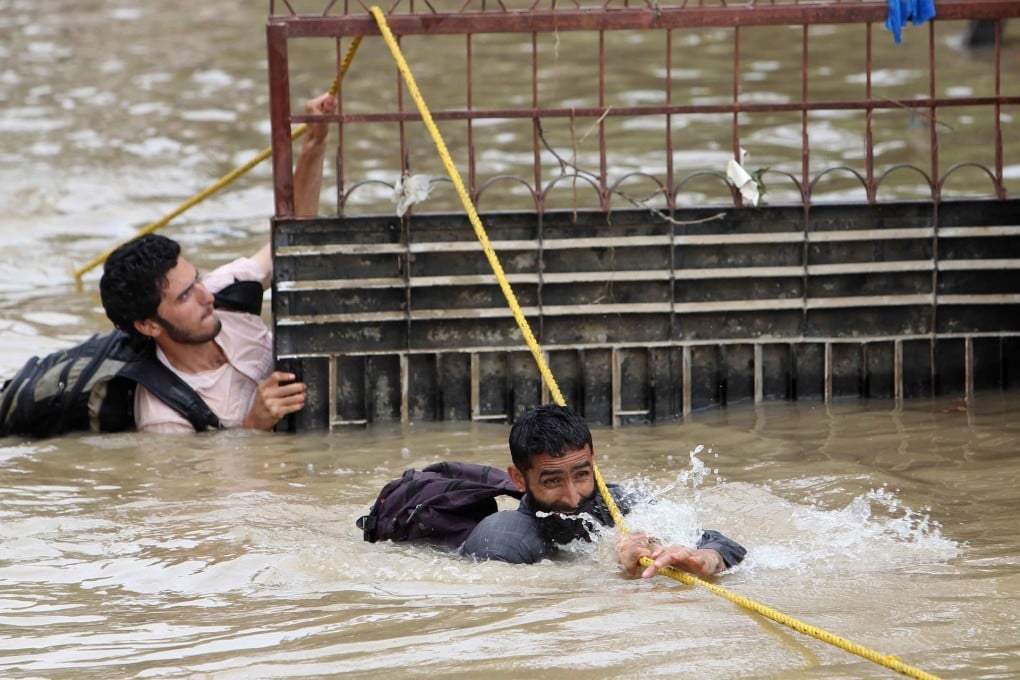 Volunteers wade through floodwaters to distribute relief supplies in Srinagar, the capital of Indian-controlled Kashmir. Photo: Xinhua