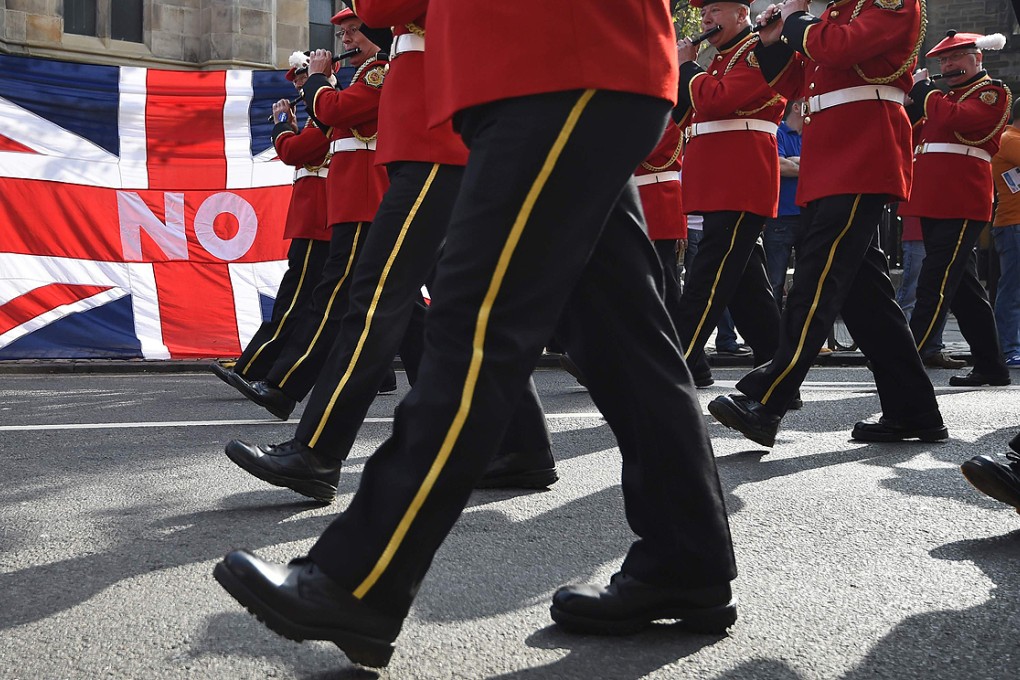Band members march past a Union flag during a pro-Union rally in Edinburgh, Scotland on Saturday. Photo: Reuters