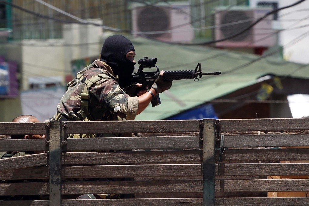 A Filipino soldier fires his M-16 rifle during a 2013 stand-off in Zamboanga city, a frequent site of clashes with rebels. A  Chinese teenager was kidnapped in Zamboanga Sibugay on Thursday. Photo: EPA