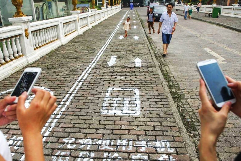 Chongqing has opened a 30 metre dedicated pavement lane for mobile phone users. Photo: Xinhua
