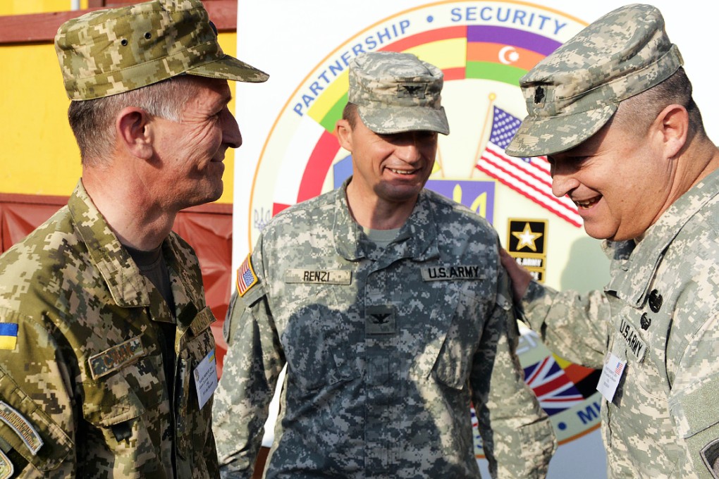 An Ukrainian serviceman (left) talks to  US counterparts following the opening ceremony of the "Rapid Trident" military exercises on September 15, 2014 near the western Ukrainian town of Yavoriv.  Photo: AFP