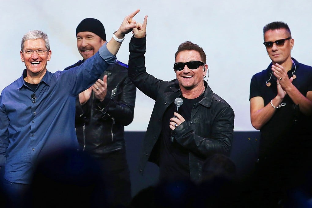Apple CEO Tim Cook (left) greets the crowd with U2 singers during an Apple special event on September 9, 2014. Photo: AFP