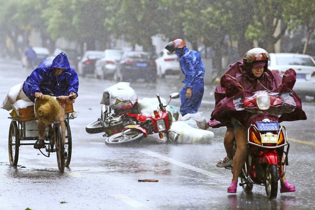 A motorcycle falls on the street as residents ride their vehicles against strong wind from Typhoon Kalmaegi. Photo: Reuters