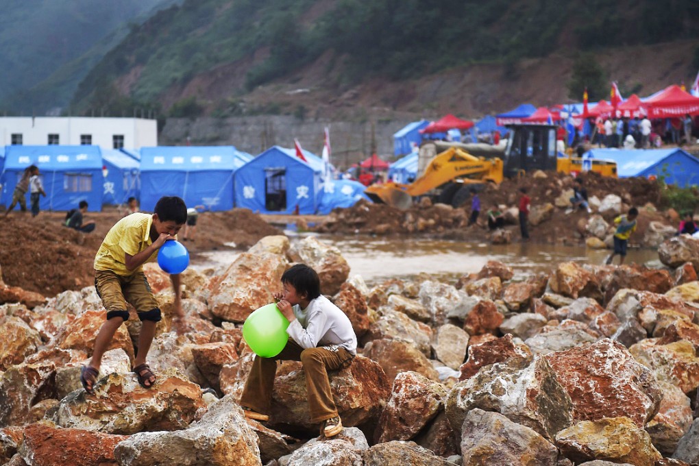 Children are seen playing near their temporary settlement site at the earthquake zone in Ludian county last month as scientists are now disputing what role filling in the reservoirs might have played in the destruction. Photo: Reuters