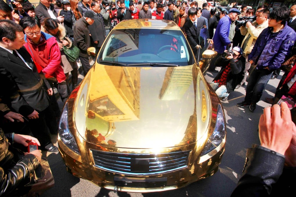 A crowd gather to admire a gold-plated sports car in Nanjing, China. Photo: AFP