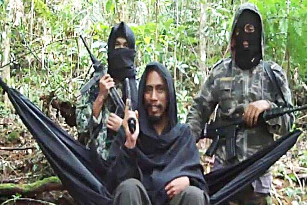 East Indonesia Mujahideen leader Abu Wardah Santoso flanked by two masked militants. Photo: AP