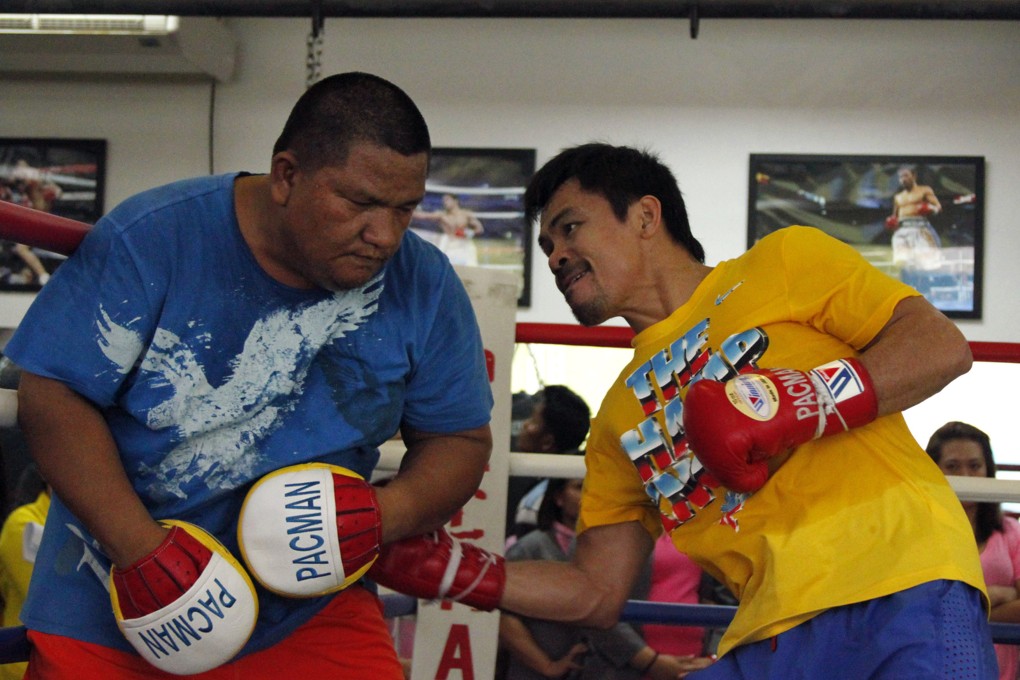 Manny Pacquiao (right) spars with assistant trainer Buboy Fernandes at a gym in General Santos City in Mindanao in preparation for his November bout with Chris Algieri. Photo: AFP