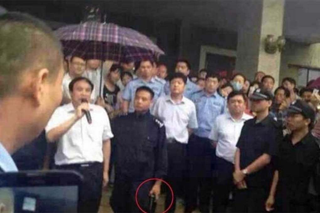 Picture showing Henan official Wu Zhenfu being sheltered from the rain by a police officer's umbrella attracted much criticism online. Photo: SCMP Pictures