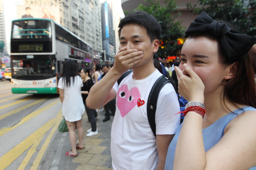 Pedestrians do their best to fend off the pollution in Causeway Bay yesterday. Photo: Edward Wong