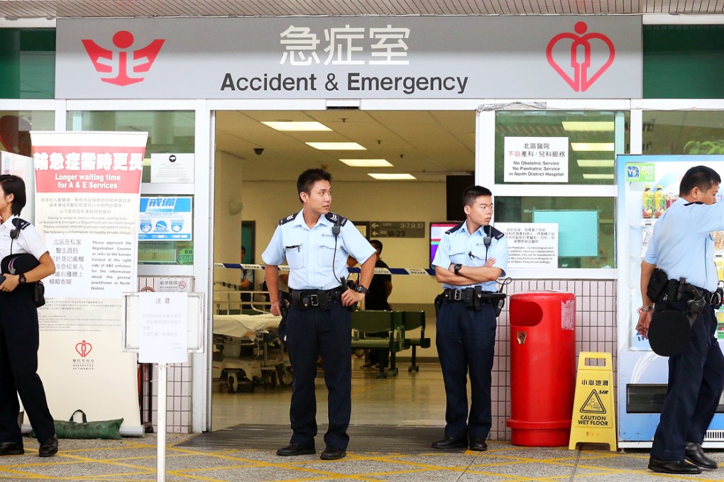 Police officers stand guard after shooting happened at the North District Hospital in Sheung Shui.