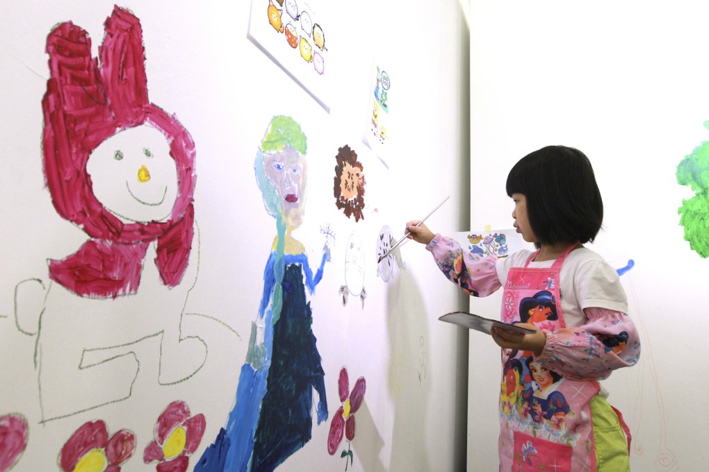 A child uses the wall at Artify, in Chai Wan, as her canvas.