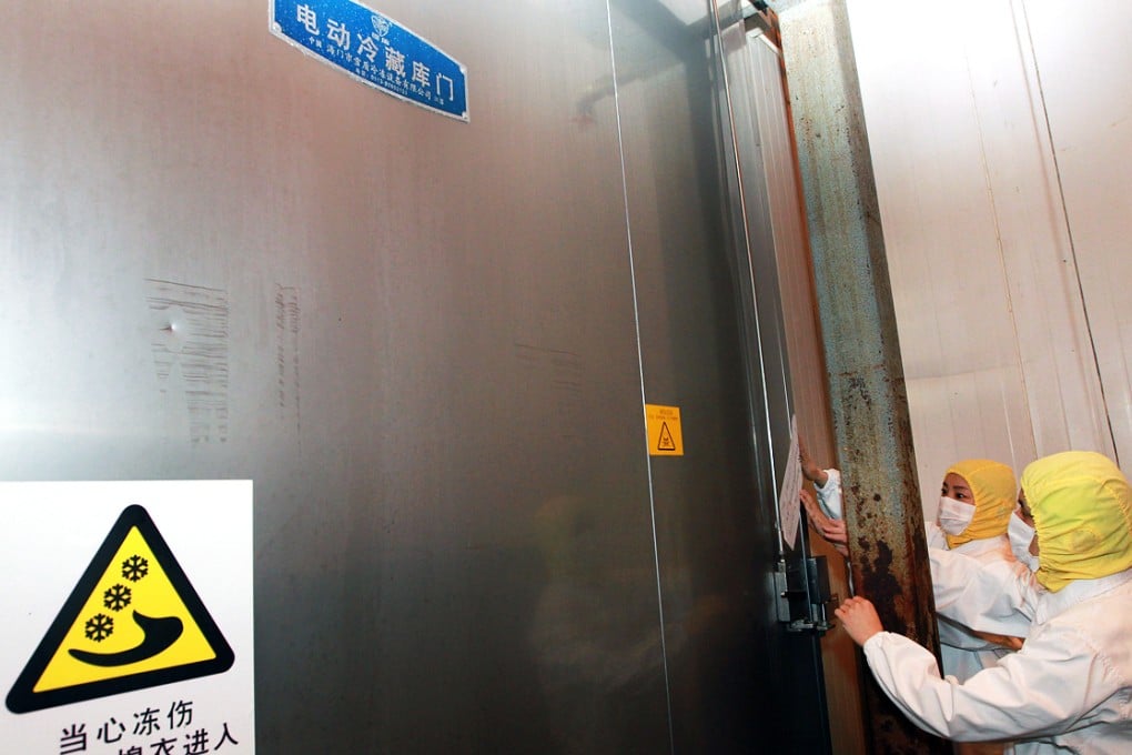 A file picture taken in July shows staff shutting the door to a storeroom at the now-closed Shanghai Husi plant. Photo: Xinhua