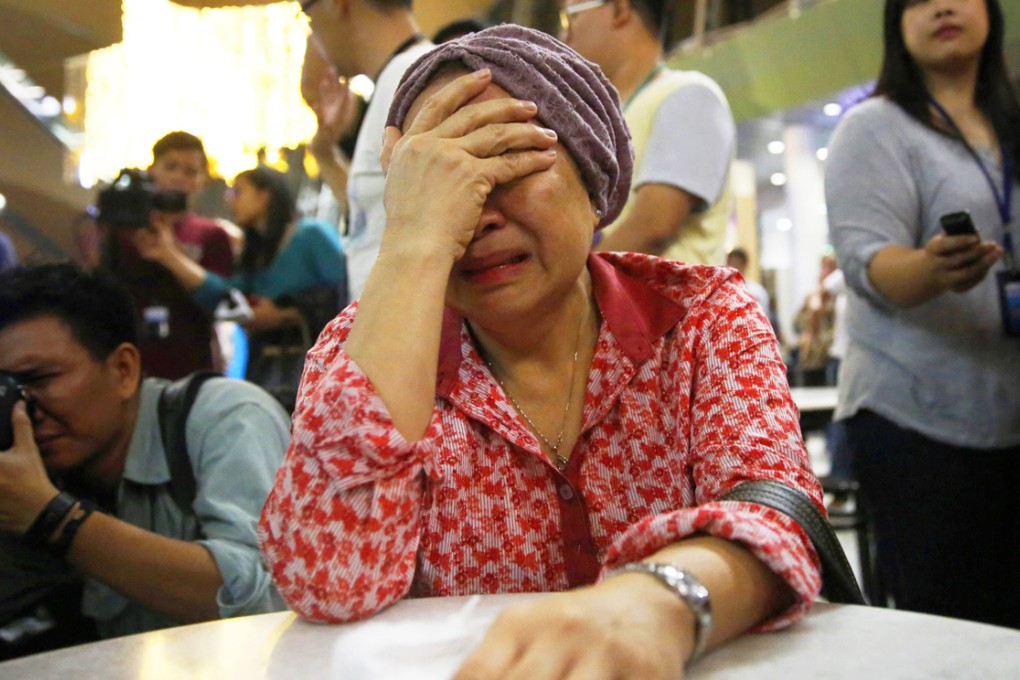 A woman, who said her sister was on Malaysia Airlines flight MH17, cries upon news of the airplane's disappearance. Photo: Reuters