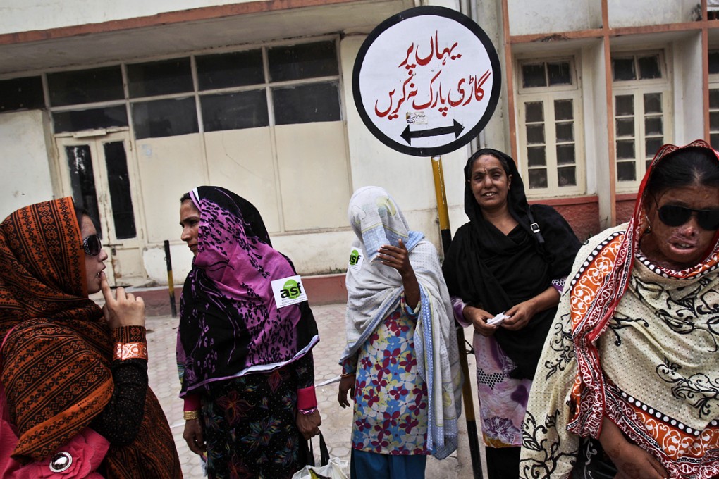 A Pakistani woman (fourth from left) whose nose was sliced by her husband stands with acid attack survivors stand outside a hospital. Acid attacks, which disfigure and often blind their overwhelmingly female victims, have long been used to settle personal or family scores in Pakistan. Photo: AP
