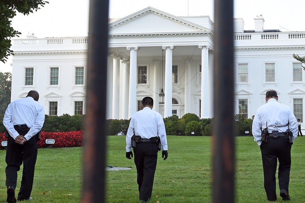 Uniformed Secret Service officers walk along the lawn on the north side of the White House in Washington. Photo: AP