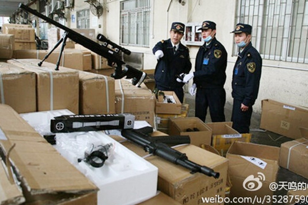 Shenzhen border police  inspect one of the smuggled air guns.
Photo: Weibo