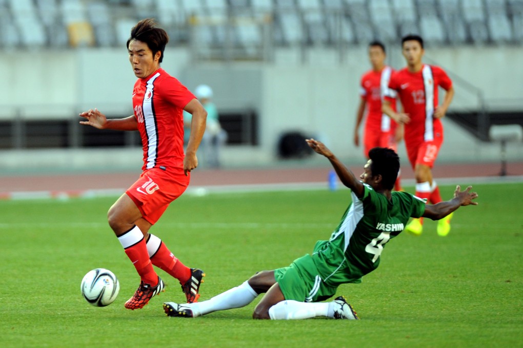 Hong Kong's  Ju Yingzhi  vies for the ball with Khan Yeasin of Bangladesh in their match in Incheon. Photo: Xinhua