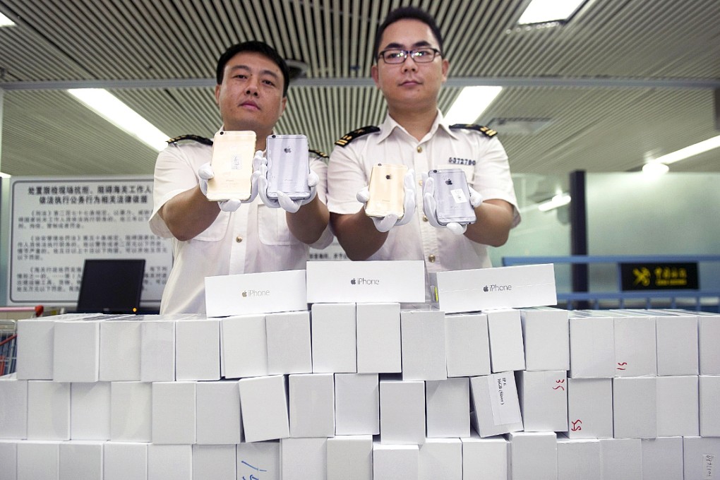 Customs officers display smuggled iPhone 6 sets, which were seized at the customs of a port in Shenzhen. Photo: Reuters