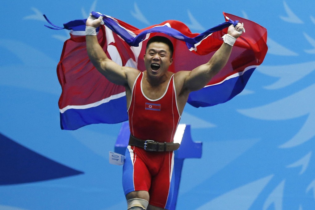 North Korea's Kim Un-guk celebrates after breaking his second world record of the night and winning a gold medal in the men's 62kg weightlifting competition at the Moonlight Garden venue. Photo: Reuters