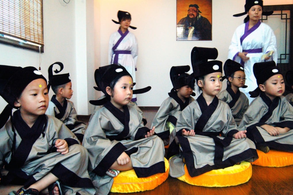 Children attend classes near a portrait of ancient philosopher Confucius at a private school dedicated to his teachings in Wuhan, Hubei province. Such schools have grown in popularity in recent years. Photo: AP