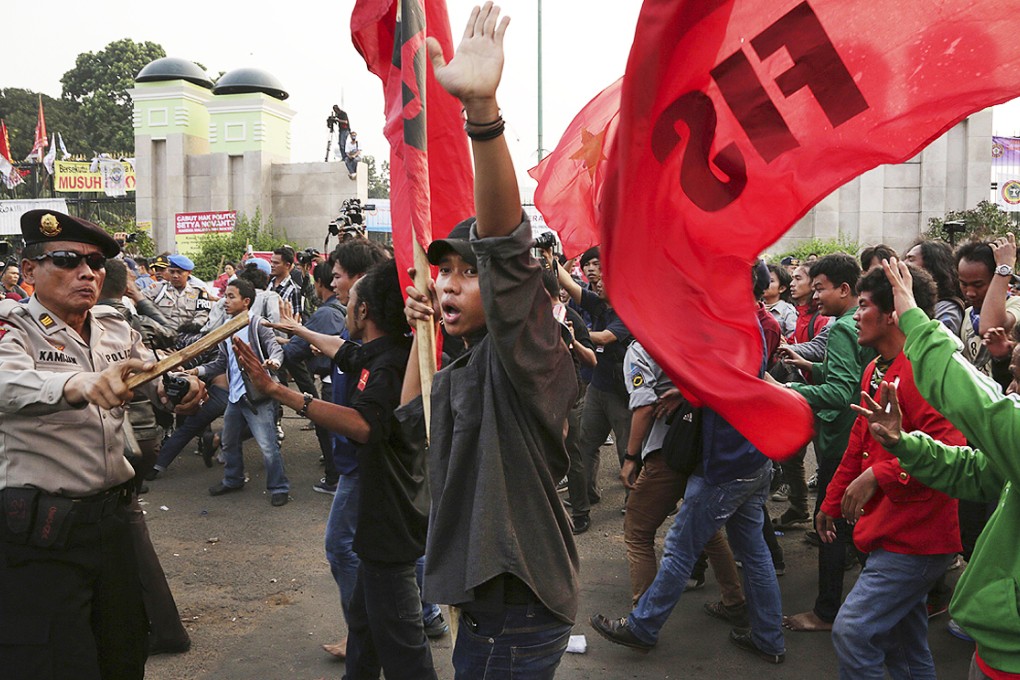 Indonesian police block protesters during a rally opposing the regional election bill in front of the parliament building in Jakarta on Thursday. Photo: AP