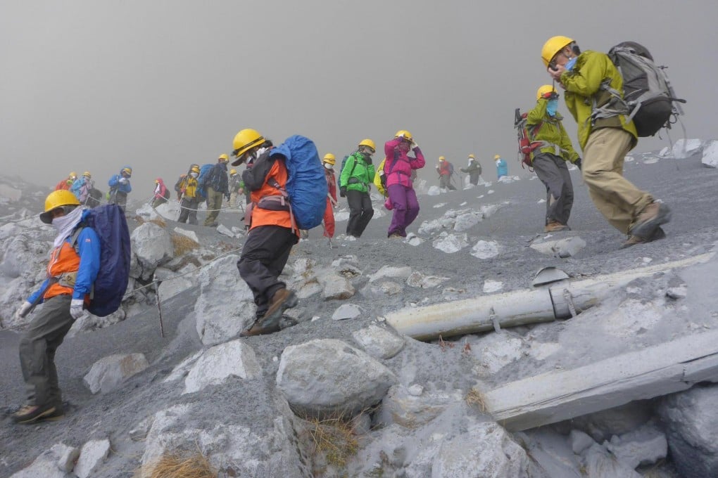 Climbers scramble for safety down the slopes of Mount Ontake in central Japan as the volcano erupts. The eruption injured at least 40, and some were missing. Photo: AP