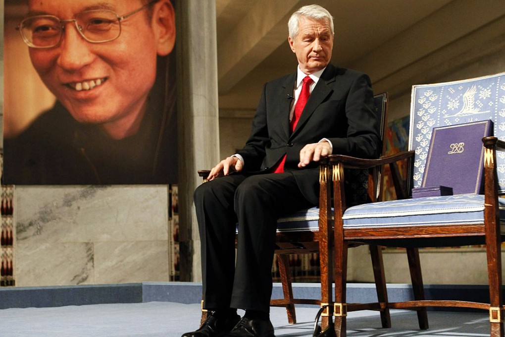 Chairman of the Nobel Committee Thorbjoern Jagland looks at the reserved vacant chair of Nobel Laureate Liu Xiaobo (portrait at left), on which Jagland placed the Nobel Peace Prize diploma and gold medal during the ceremony for the Nobel Laureate and dissident Liu Xiaobo at the city hall in Oslo on December 10, 2010. Photo: AFP