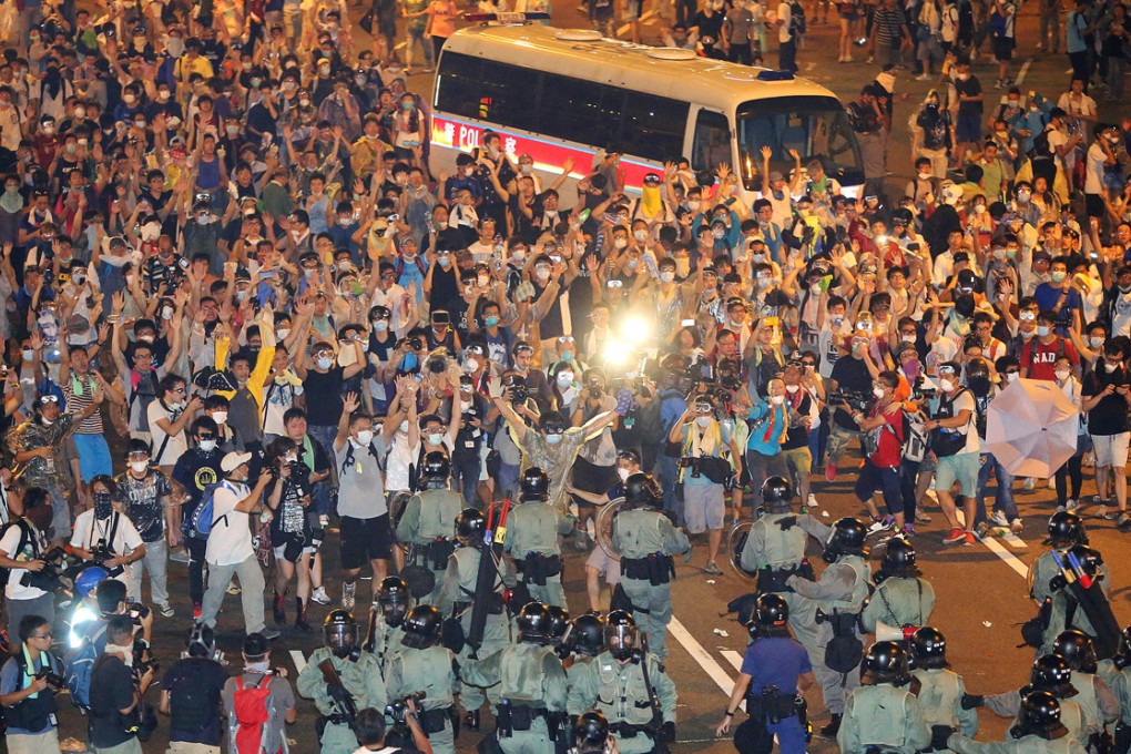 Riot police armed with tear gas confront protesters at Connaught Road Central in Admiralty. Protesters used goggles, masks and umbrellas as shields. Photo: Sam Tsang