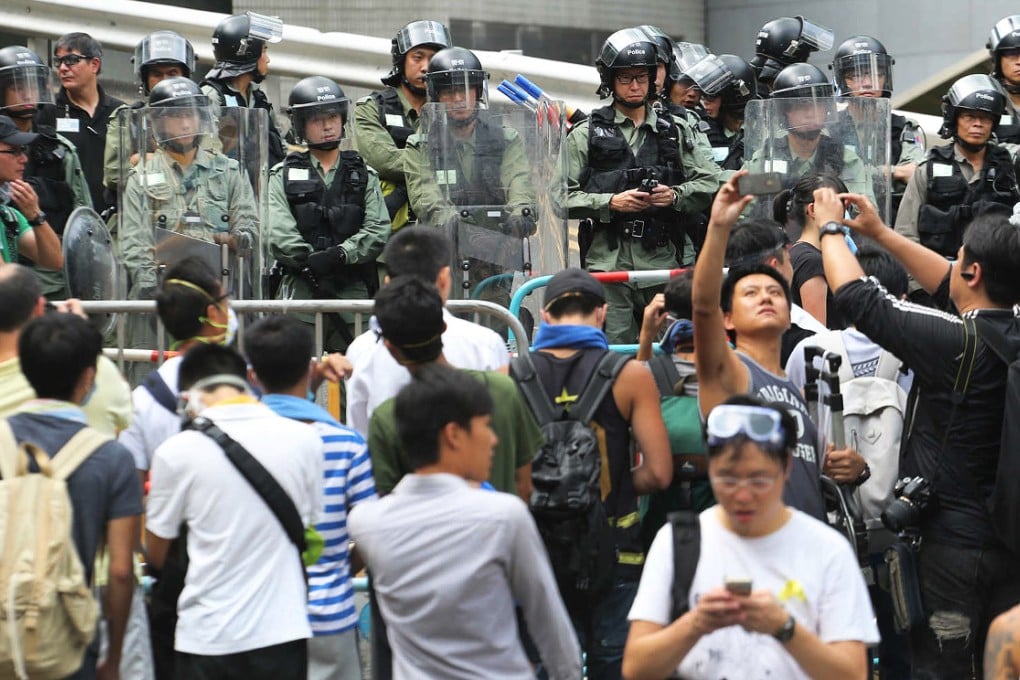 Riot police with shields guard a street in Admiralty around noon on Monday. Photo: David Wong