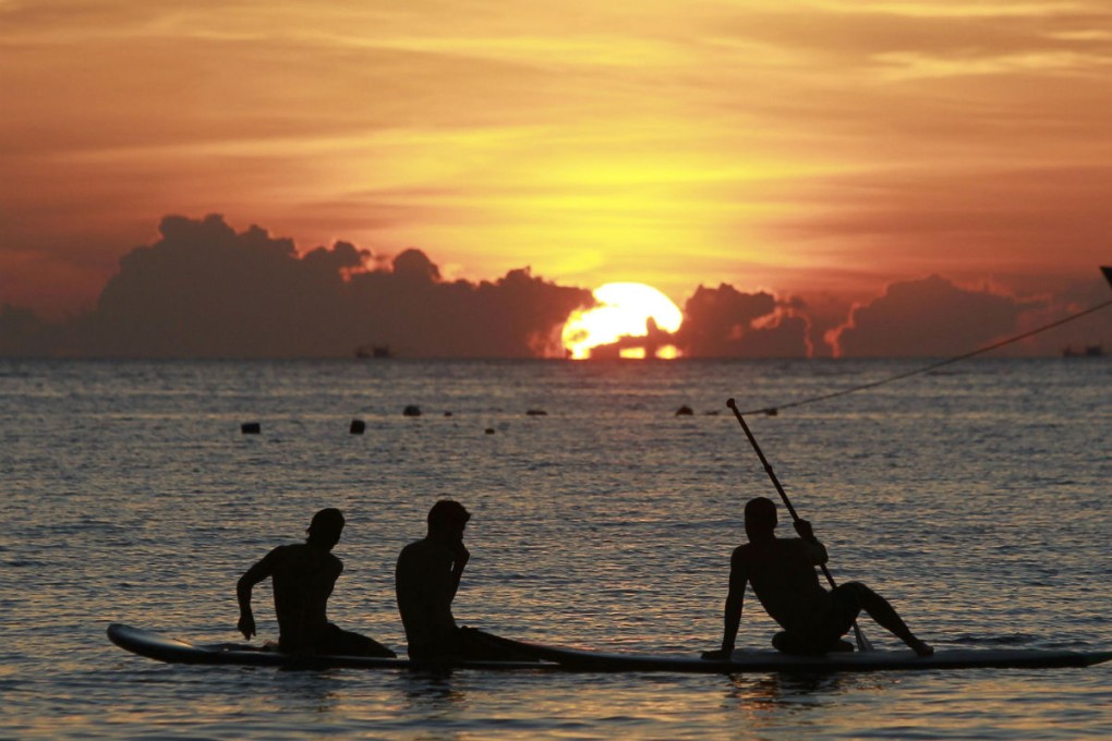 Tourists watch the sun sets on the island of Koh Tao, where two British backpackers were murdered earlier this month. Photo: Reuters