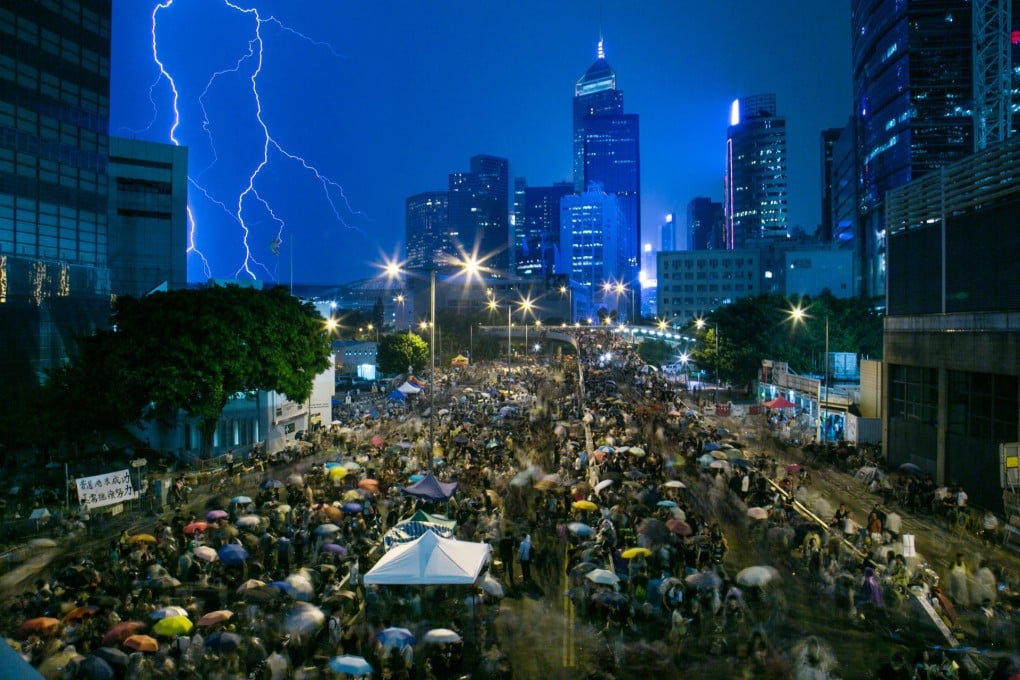 Lightning strikes as protesters gather outside the central government offices. Many began singing in the rain. Photo: Bloomberg