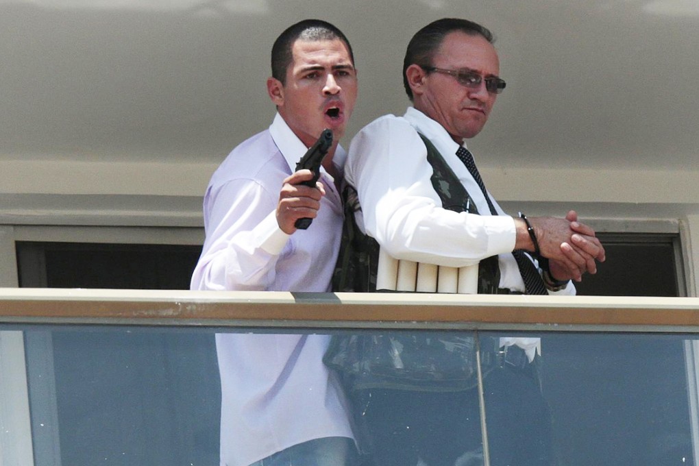 The man and the hostage on a hotel balcony. Photo: Reuters