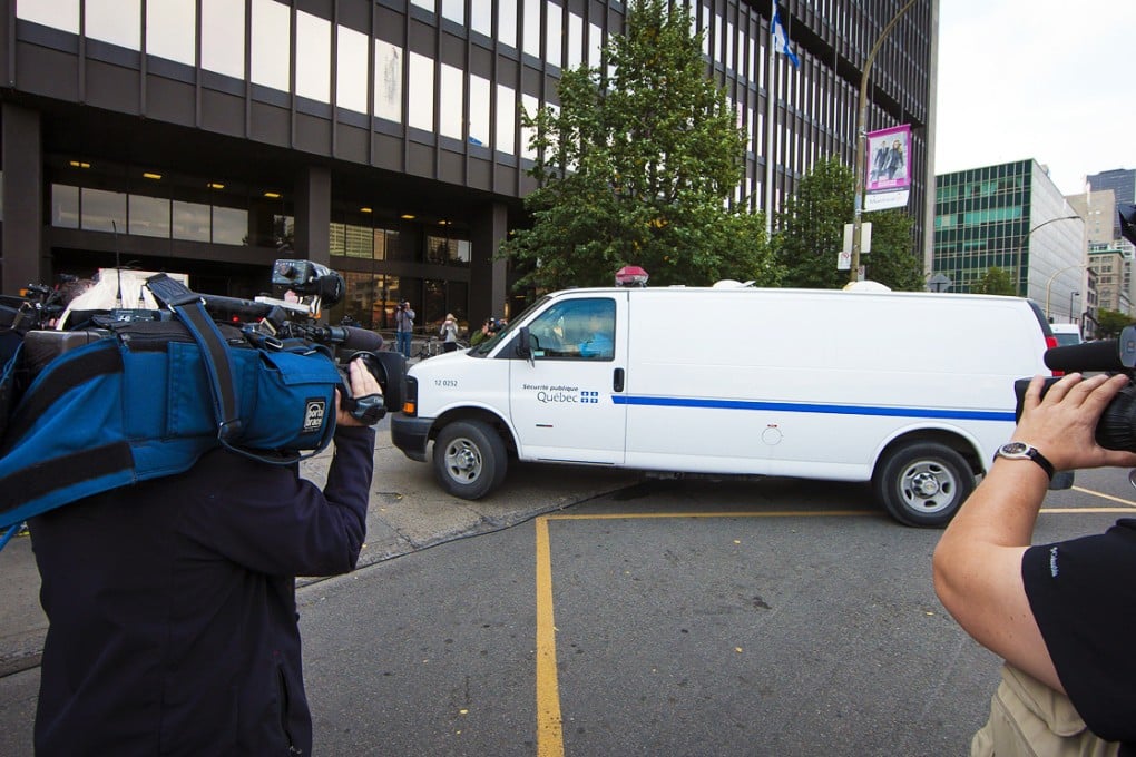 Reporters film a prison van carrying defendant Luka Magnotta arriving at court in Montreal, Canada on the first day of Magnotta's murder trial. Photo: EPA