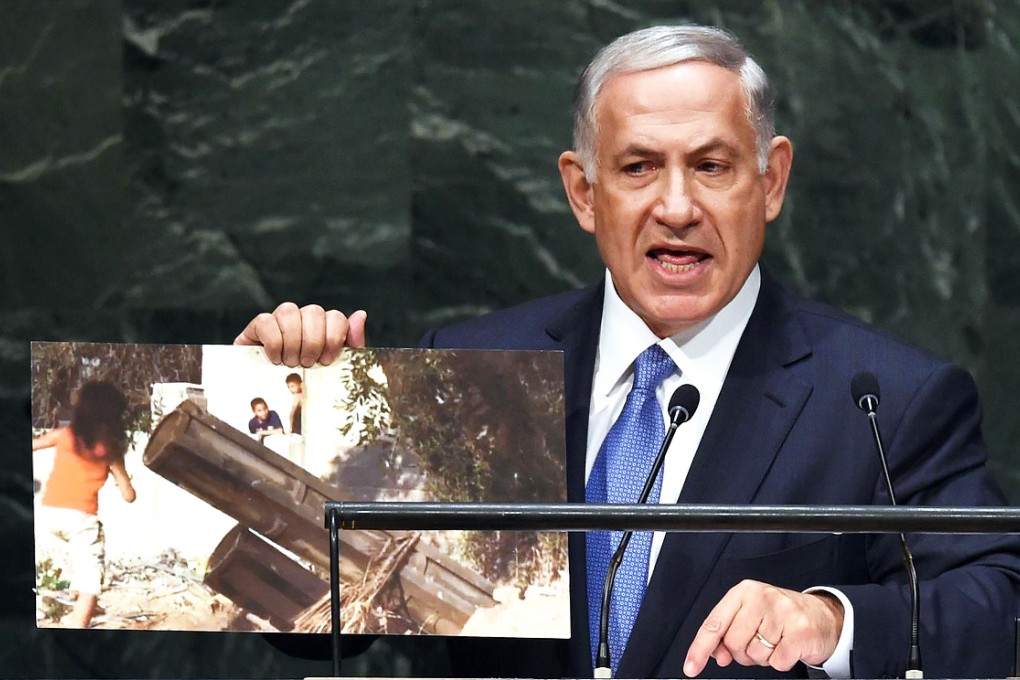 Isarelai Prime Minister Benjamin Netanyahu holds up a photo of an alleged Hamas rocket as he addresses the 69th Session of the UN General Assembly in New York. Photo: AFP