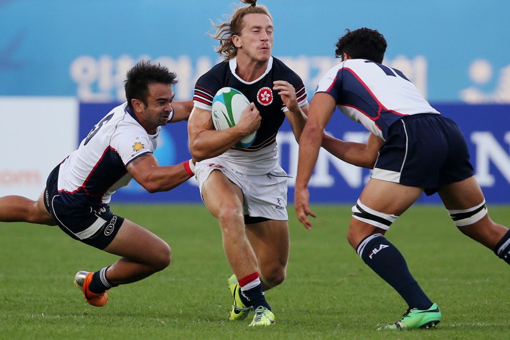 Hong Kong's Tom McQueen has his hands full as he faces two players from the Philippines ready to tackle him during their match. Photos: Nora Tam