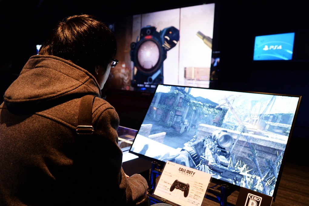 A visitor plays 'Call Duty Ghosts' during the "Try! PlayStation 4" event at Ginza Sony building in Tokyo. Photo: AFP