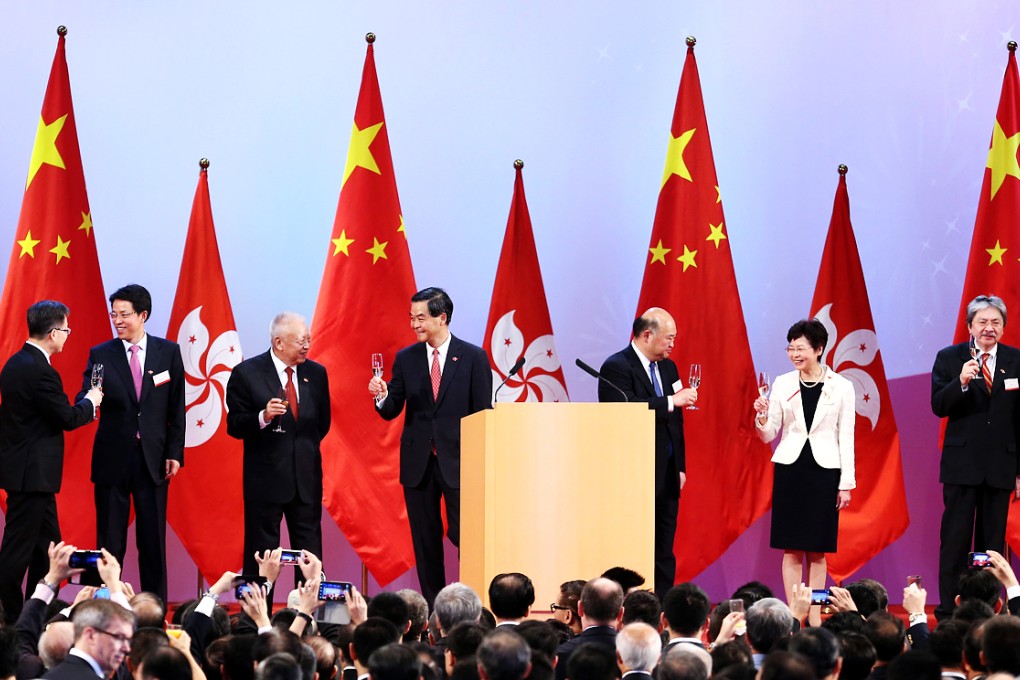 C.Y. Leung and officials raise a toast - ignoring thousands of booing protesters outside. Photo: K.Y. Cheng