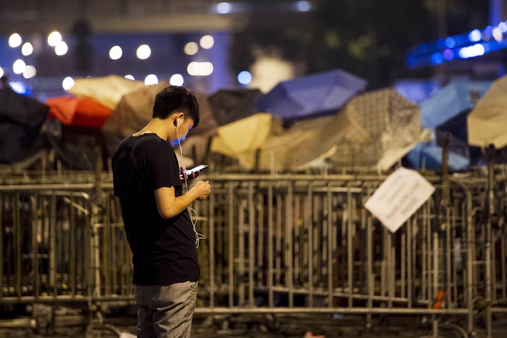 A pro-democracy demonstrator checks his phone in Hong Kong. Security experts have warned a virus may be targeting protesters in the city. Photo: AFP
