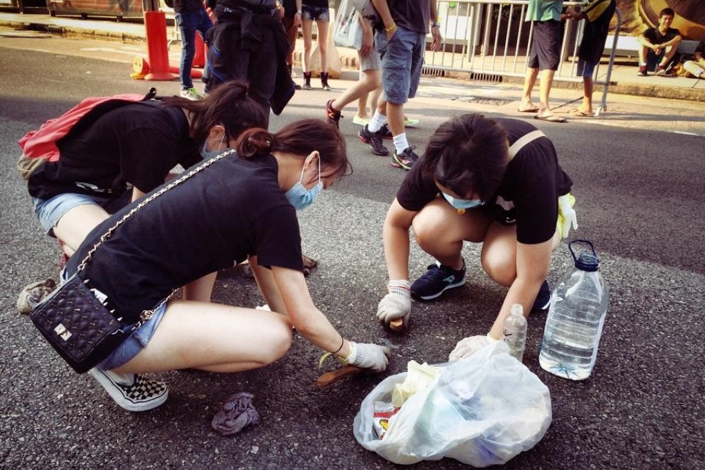 Volunteers are seen carrying bulging plastic bags and cleaning the street. Photos: Jason Y Ng