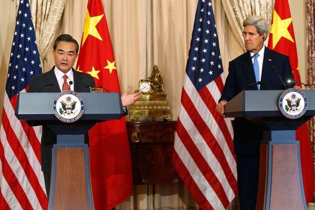China's Foreign Minister Wang Yi delivers remarks as US Secretary of State Kerry looks on. Photo: Reuters