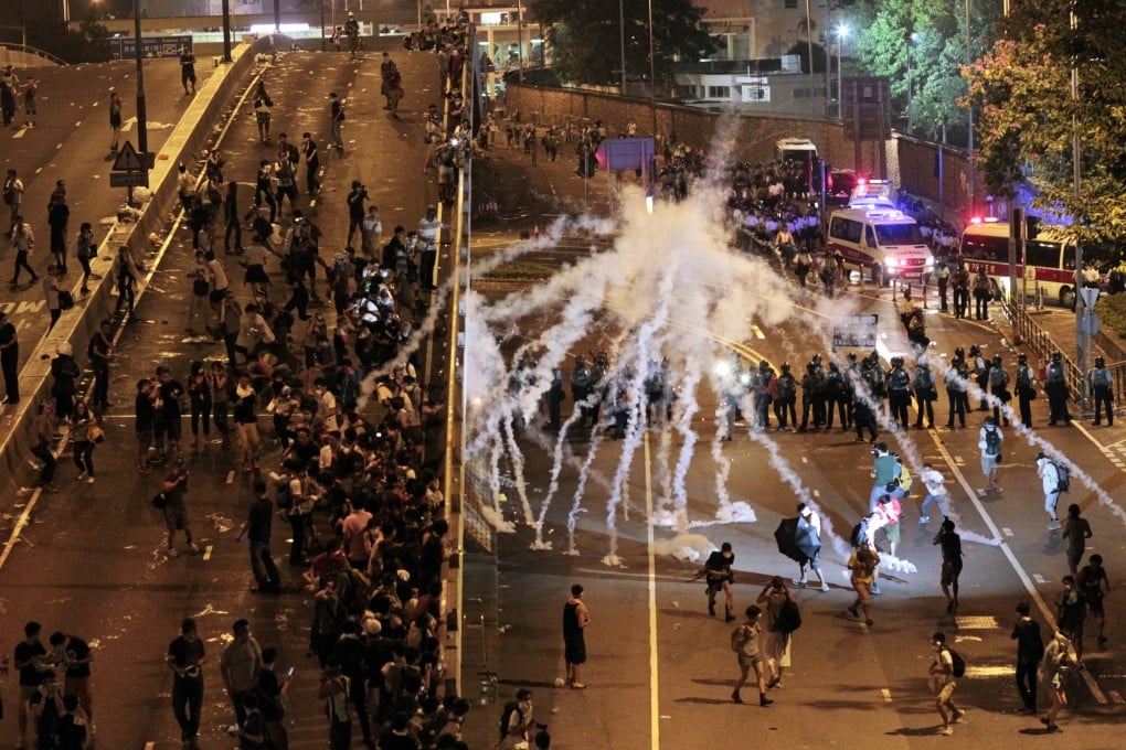 Police fire tear gas at protesters on Sunday night. Photo: AP