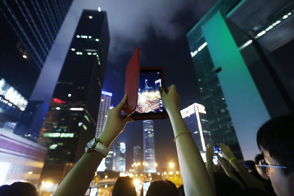 A woman takes a picture of the protests. Photo: Sam Tsang