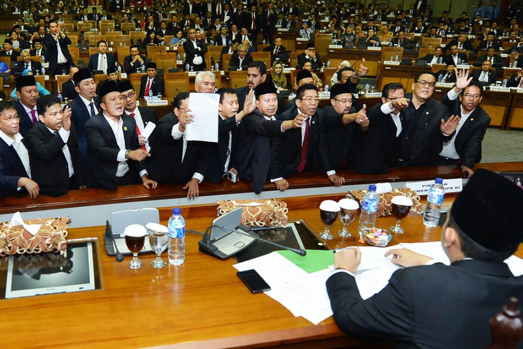 Newly inaugurated legislators who support president-elect Joko Widodo protest to the head of the plenary session in Jakarta after opposition politicians won a number of key posts. Photo: AFP