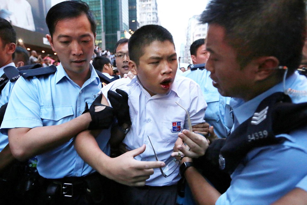 A student protester bleeds as he is escorted to safety by police in Mong Kok. There were further confrontations in Causeway Bay and Tsim Sha Tsui. Photo: Sam Tsang