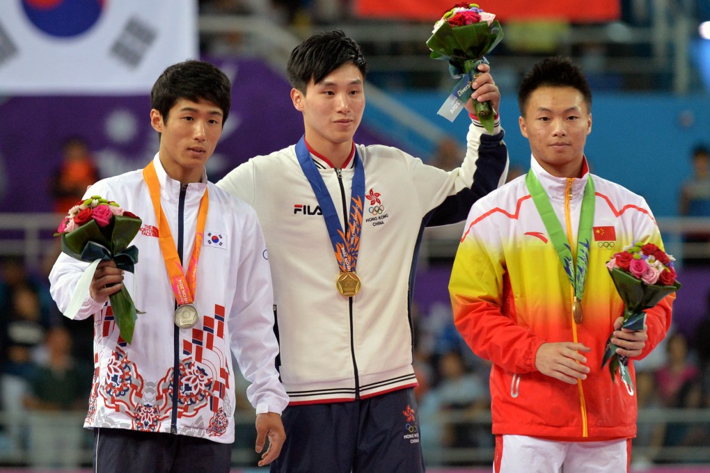 Hong Kong's Shek Wai-hung celebrates an unlikely gold in the men's fault ahead of South Korea's Yang Hakseon bronze medalist Huang Xi of China. Photo: Xinhua