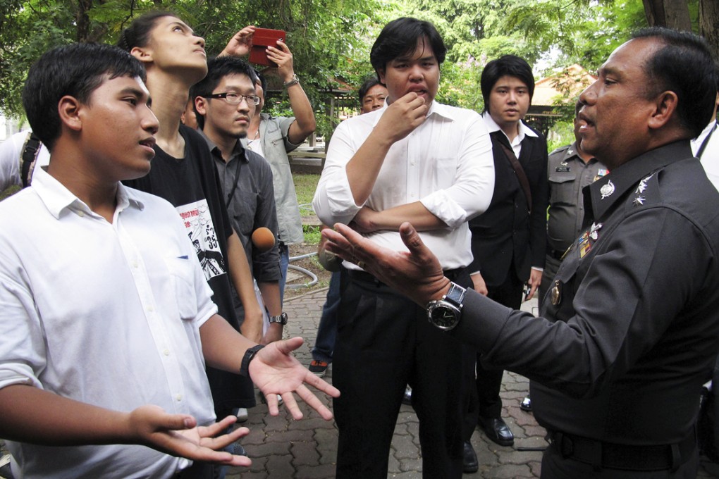 Three students Sirawit Serithiwat (left), Ratthapol Supasopon (second left) and Worawut Butrmatr (fourth from the left) negotiate with deputy provincial police chief Col. Surasak Khunnarong (right) to let an academic seminar go on at Rangsit campus of Thammasat University in Pathum Thani, Thailand on September 18, 2014. Photo: AP