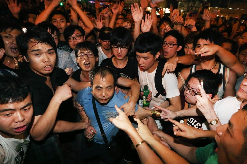 Students point at a man who allegedly attacked Occupy protesters. He was later taken away by police. Photo: Felix Wong