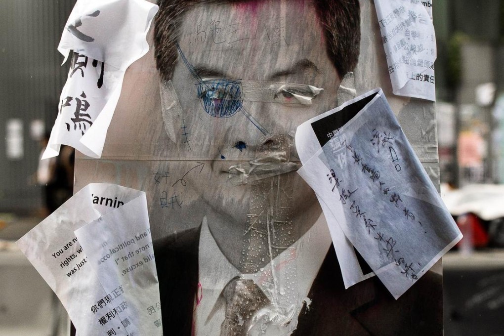 A defaced placard of Chief Executive Leung Chun-ying seen near government headquarters. Photo: AFP